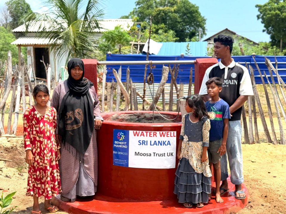 A local family, a mother, a young man and three children, standing beside the completed Moosa Trust UK water well